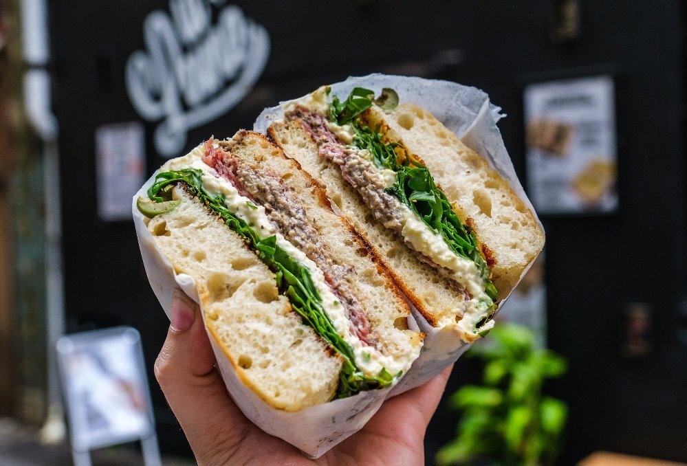 A focaccia sandwich with meat and salad in it.