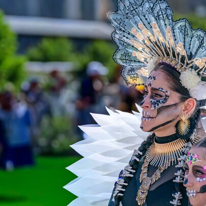 Two people in elaborate Mexican Day of the Dead costumes.
