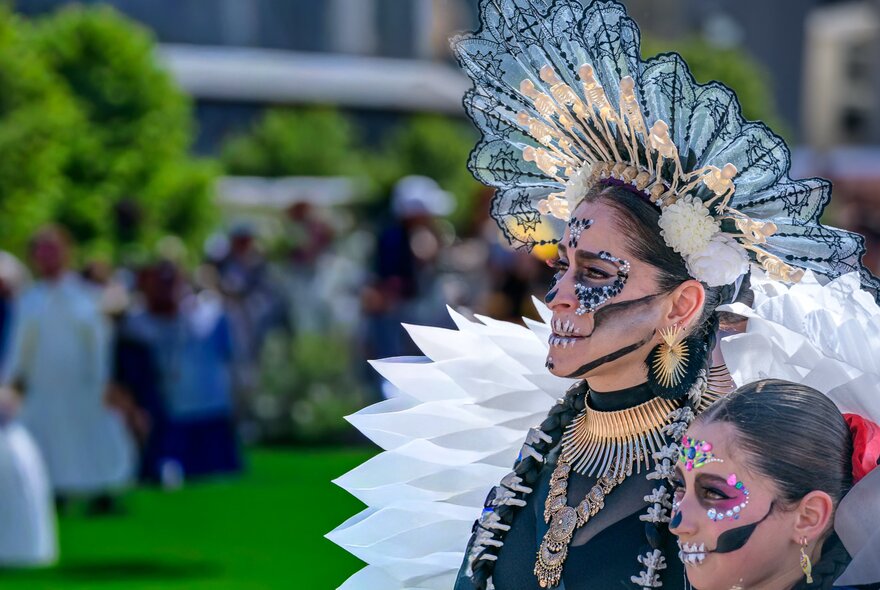 Two people in elaborate Mexican Day of the Dead costumes.