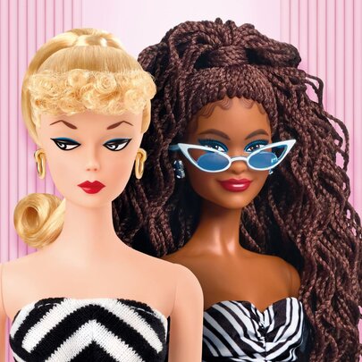Barbie dolls from an exhibition, specifically featuring a light-skinned doll with a 1959-inspired look and a dark-skinned doll with braided hair, against a pink background.