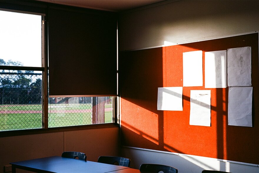 A photograph from artist, Hilary Dodd, showing the bland rear wall of a high school classroom.