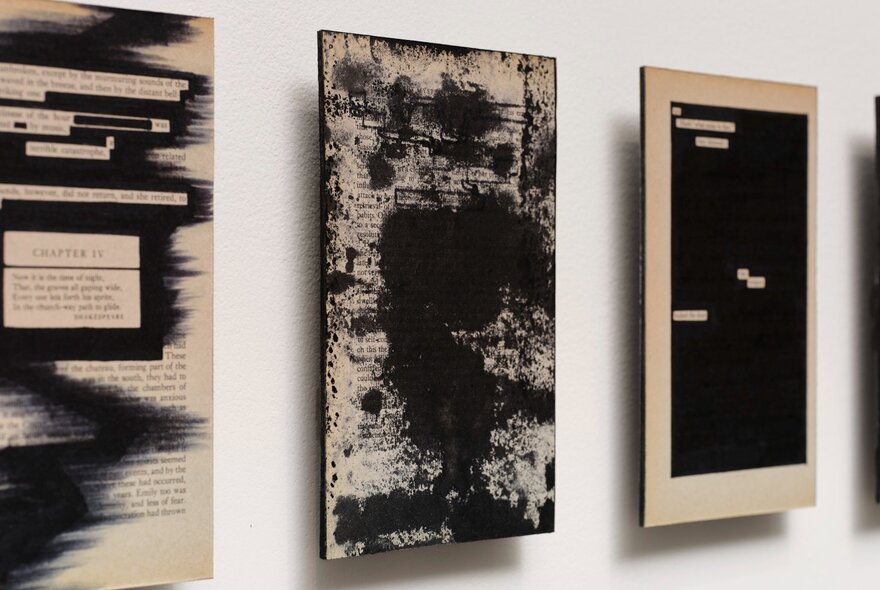 Three rectangular monochrome abstract prints hanging on a white gallery wall.