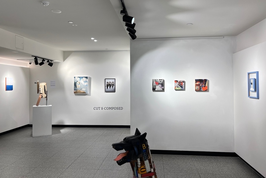 A gallery setting with artwork on the walls and sculptures on pedestals.