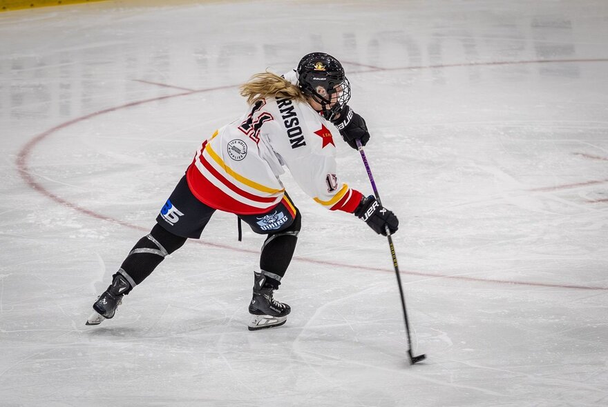 An ice hockey player skating during a match. 