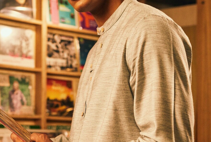 Detail of male model's casual buttoned beige top with long sleeves.