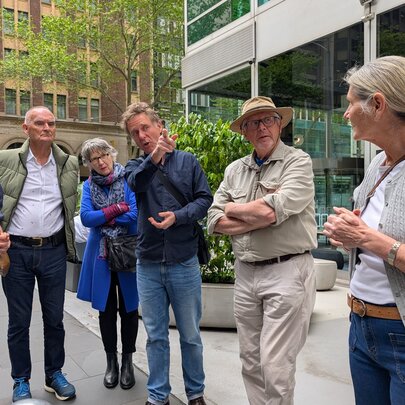 Small tour group standing in a courtyard, looking ahead.