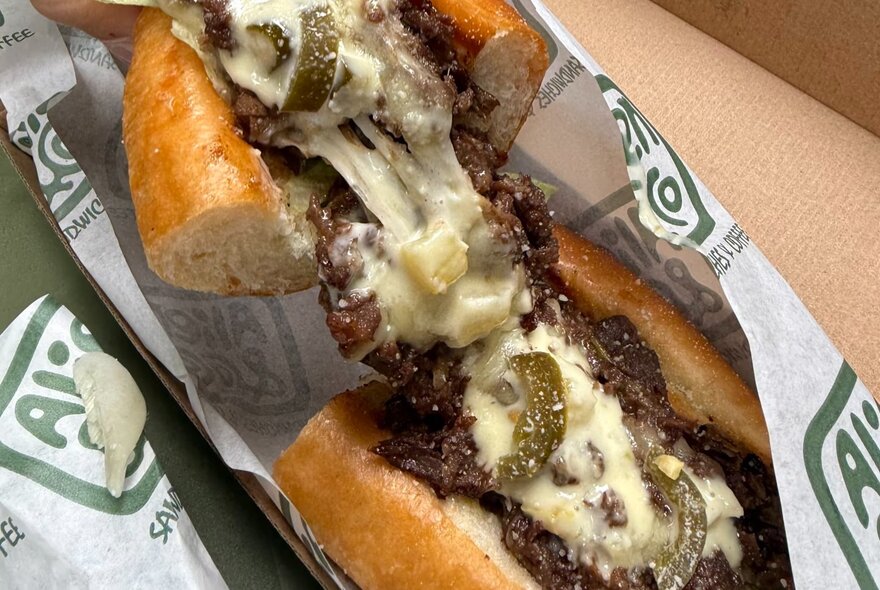 Cheese and beef sandwich in wrapper.