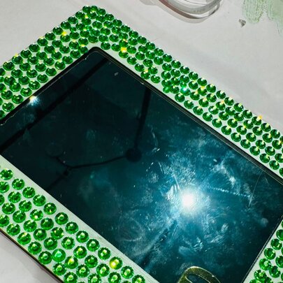 Jewelled mirror framed with green gems.