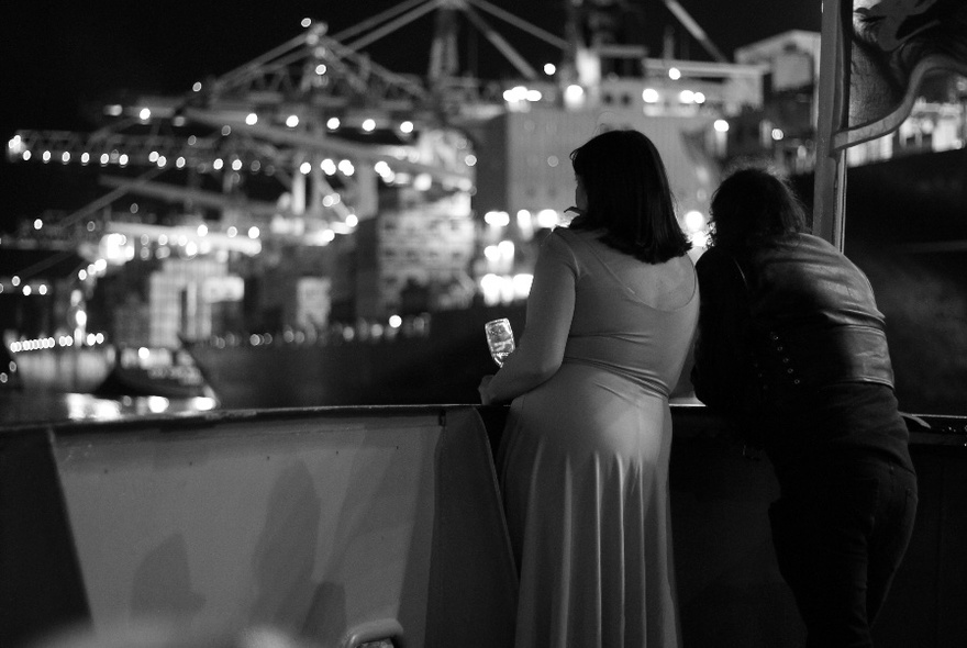 Black and white image of a couple gazing over the water from a boat.