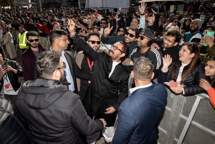 A large crowd gathered around a central figure.