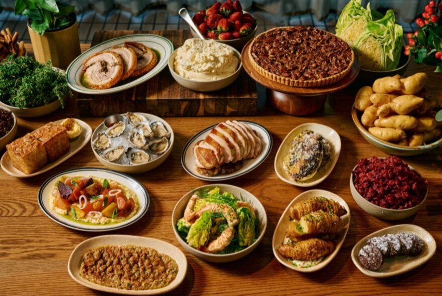 A curated spread of Christmas dishes displayed on a wooden table.