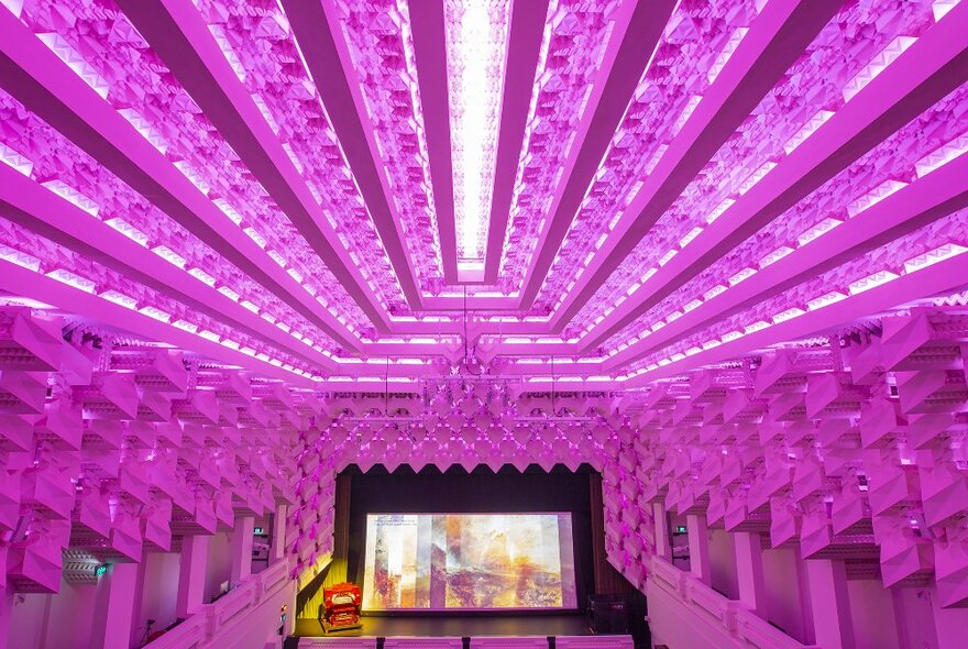 Inside an art deco theatre with a decorative ceiling.