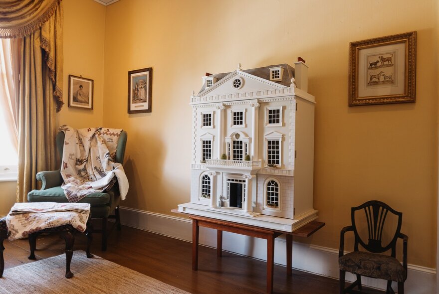 Room with Georgian-style dolls house and furnishings.