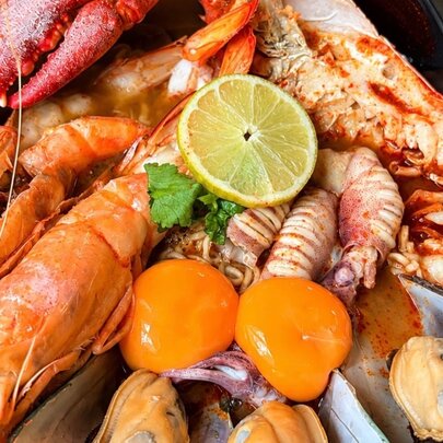An array of Australian seafood with two egg yolks and a slice of lemon on top.