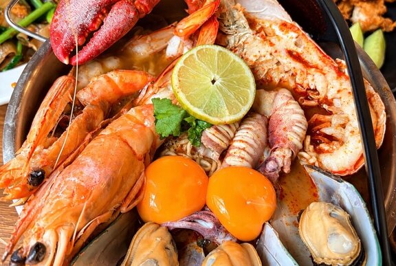 An array of Australian seafood with two egg yolks and a slice of lemon on top.