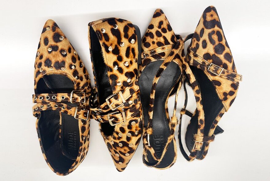 Two pairs of similar women's shoes with the same leopard print. 
