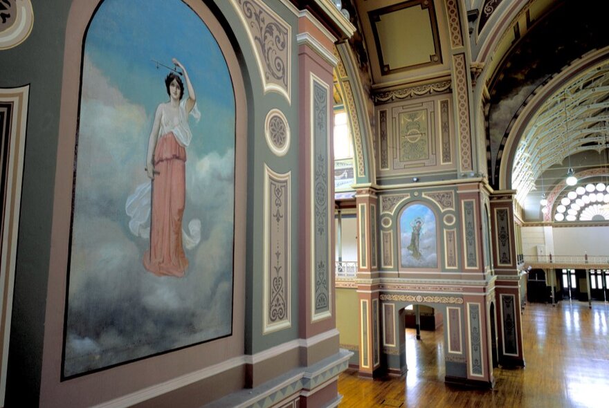 The decorative arched interior of the Royal Exhibition Building with detailed paintings on the wall. 