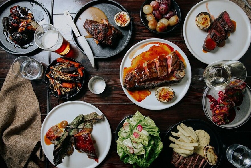 Several plates of barbequed and smoked meat.