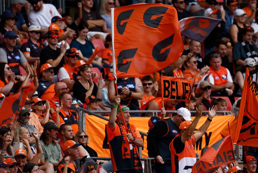 A crowd of GWS Giants fans in a stadium. 