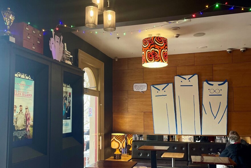 Retro lighting with lampshades and posters in a movie-themed bar.