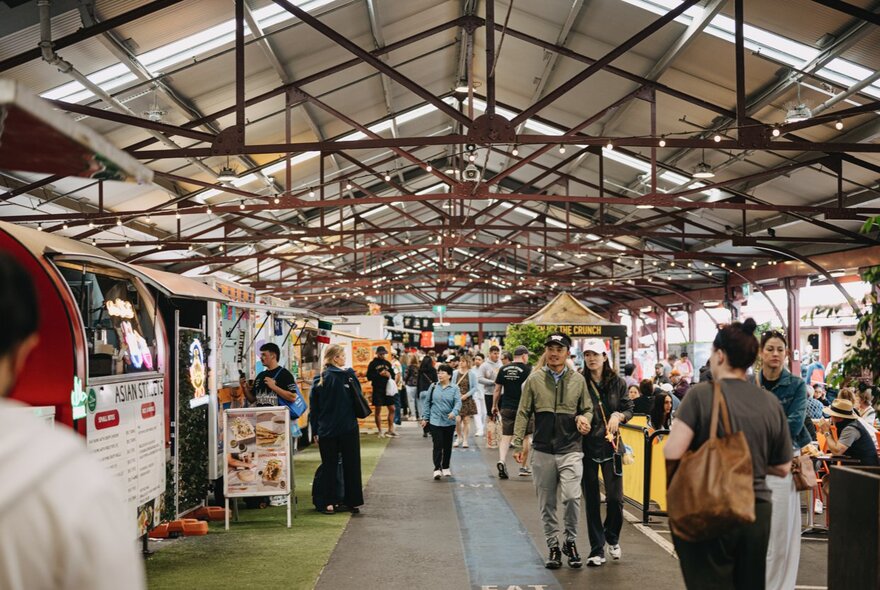 C Shed at the Queen Victoria Market, with people shopping at stalls under a large tin shed roof.