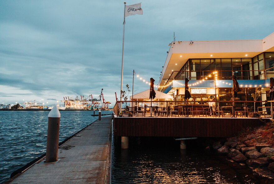 Pier 35 restaurant by the water at dusk with fairy lights on.