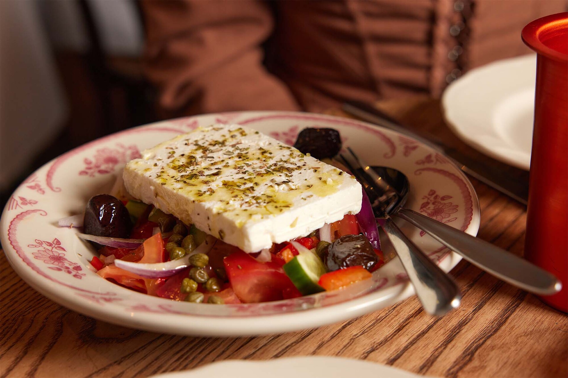 A Greek salad with a large slab of feta on top