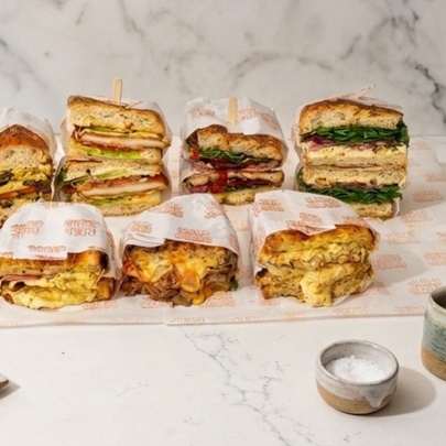 Array of filled sandwiches on a marble counter.