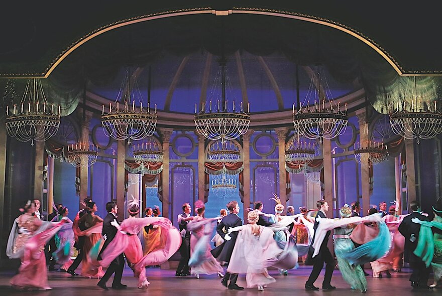 A scene from a production of My Fair Lady on stage, with the cast dancing.
