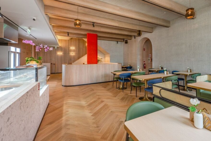 The contemporary onsite cafe at Arima Spa, with tables and chairs arranged on a pale wooden floor.