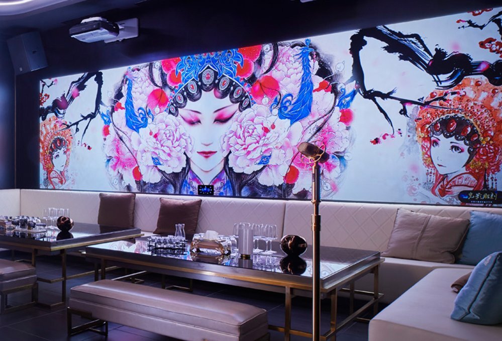 Inside a karaoke room. There is a large mural of a Chinese woman wearing traditional clothing. 