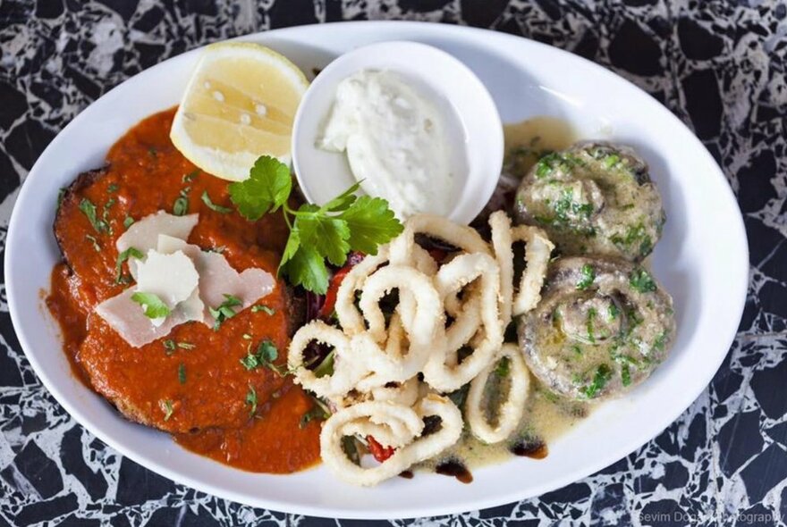 A typical Italian dish prepared by Amiconi Italian Restaurant, with pollo con napolitana, calamari and mushrooms with ricotta and lemon.