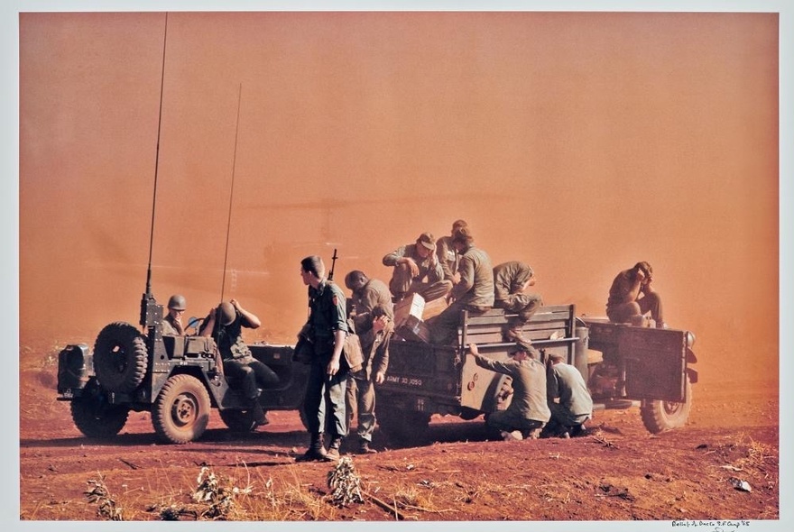 Soldiers in tanks against a sand-coloured storm cloud.