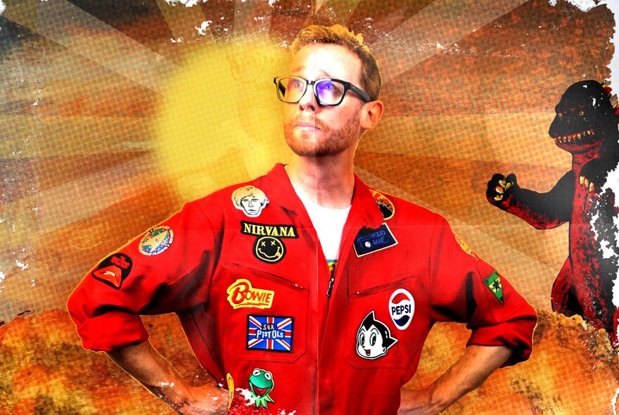 A man in a red racing suit with patches sewn all over it, standing with his hands on his hips with a cartoon godzilla in the background.