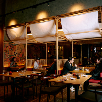 People dining in a Japanese restaurant with fabric draped overhead.