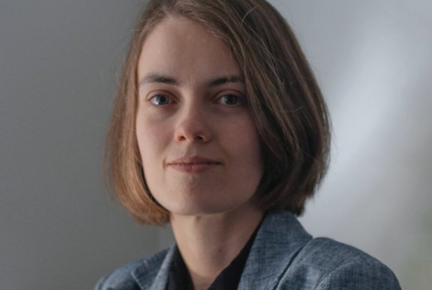 Young woman with bob haircut, smiling slightly at viewer. 