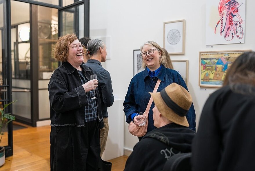 People sharing a laugh in an art gallery. 