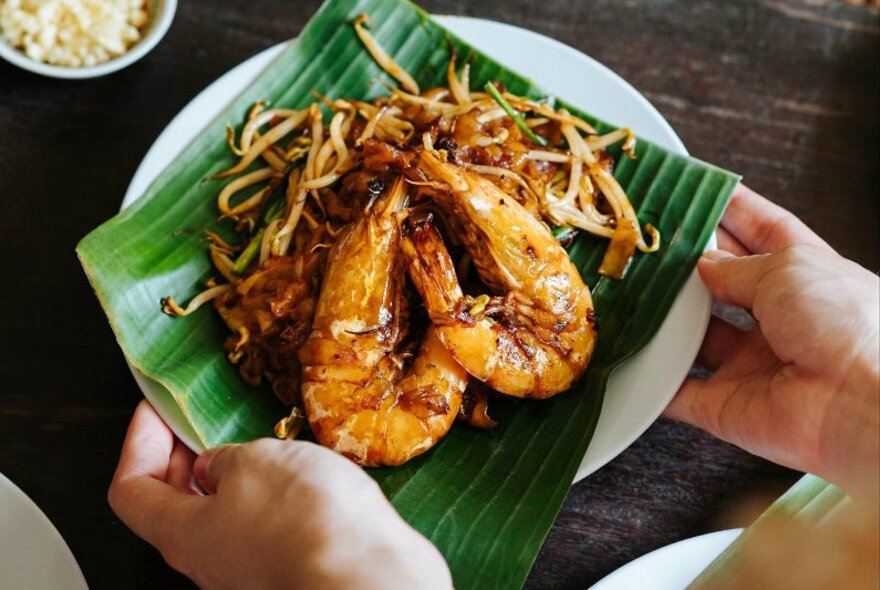 Dish of prawns presented on a green leaf.