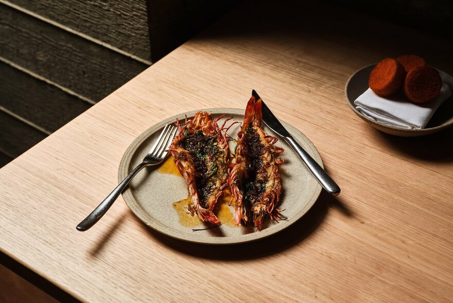 A plate and cutlery featuring grilled seafood.