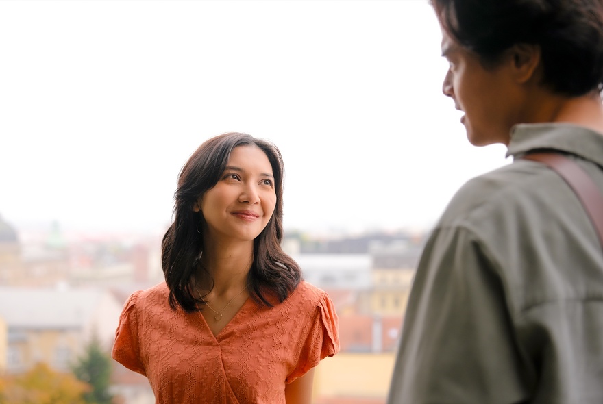 A still from the movie SORE: Wife From the Future showing a woman smiling sweetly up at a man with his back to us.