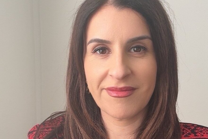 Face of author and academic Randa Abdel-Fattah, smiling with her straight brown hair framing her face.