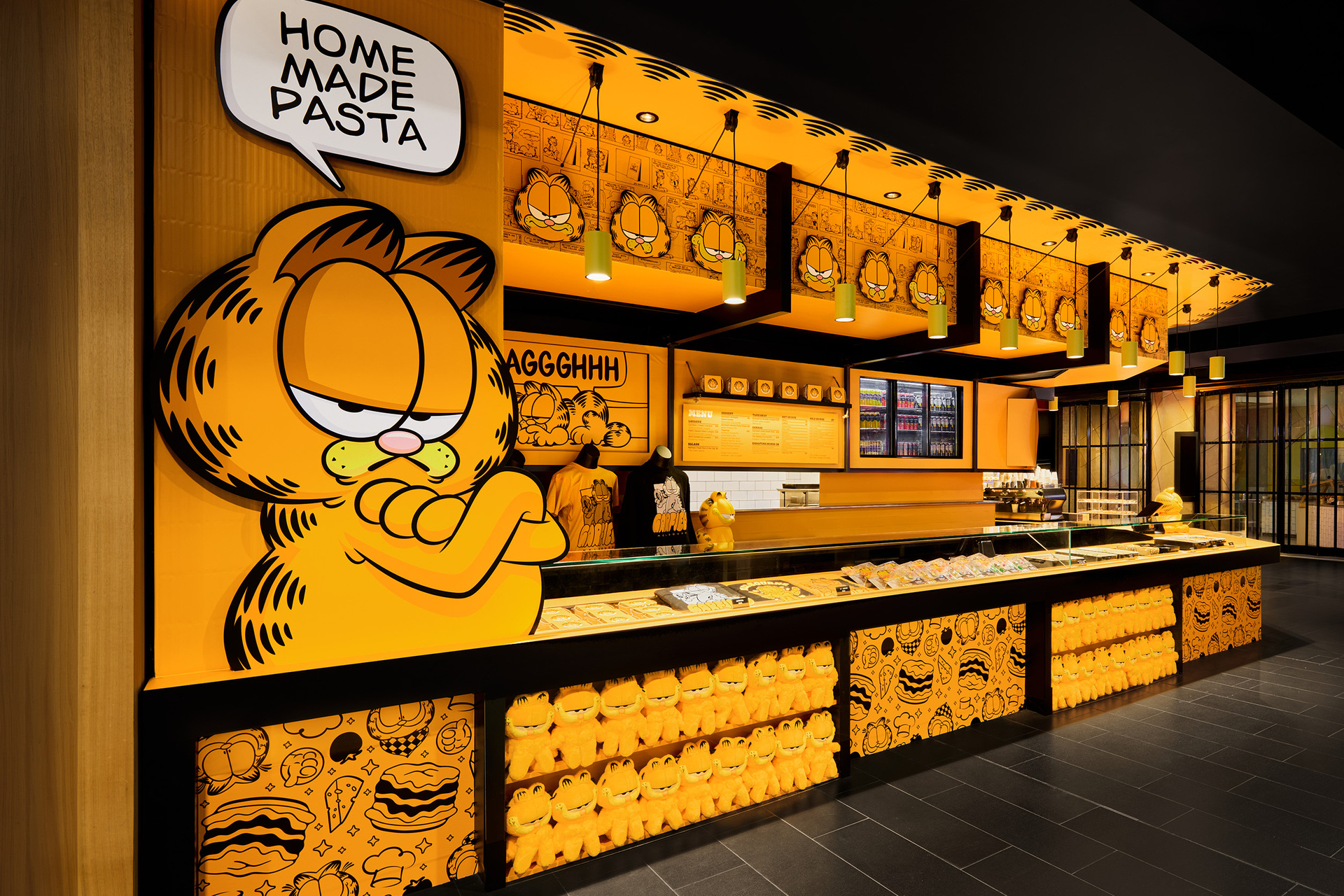 A Garfield-themed lasagne bar. There is a large illustration of garfield the cat with a speech bubble saying home made pasta. There is also merchandise for sale.