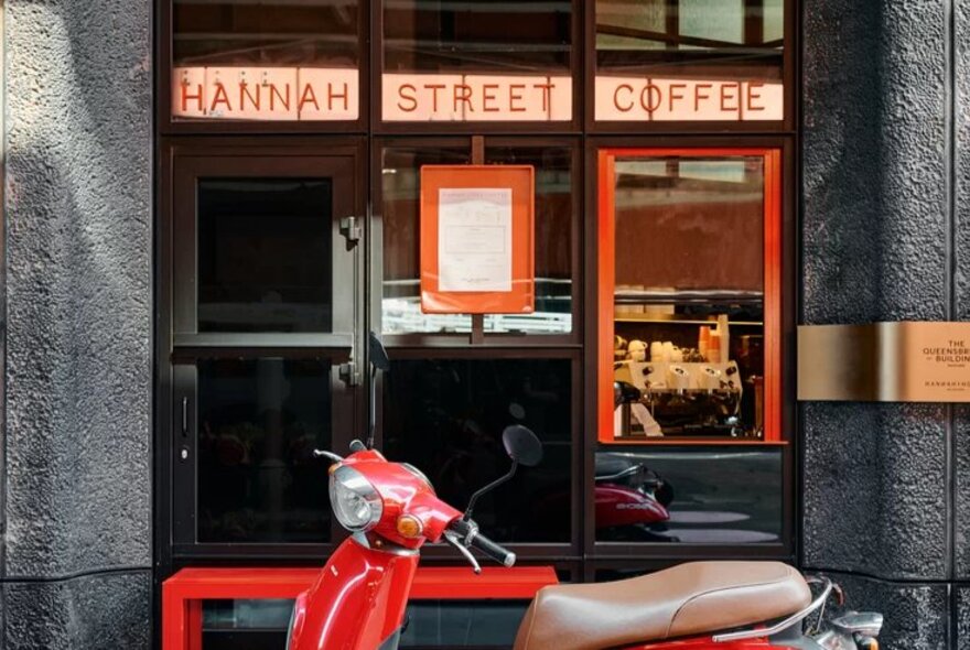 Storefront of Hannah Street Coffee shop with a red scooter parked in front.