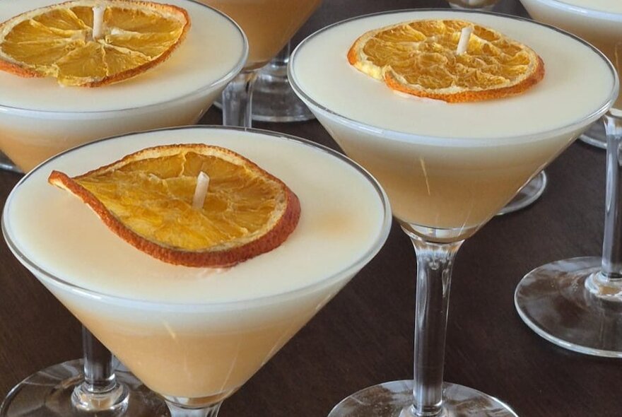 Three cocktail-inspired candles in martini glasses.