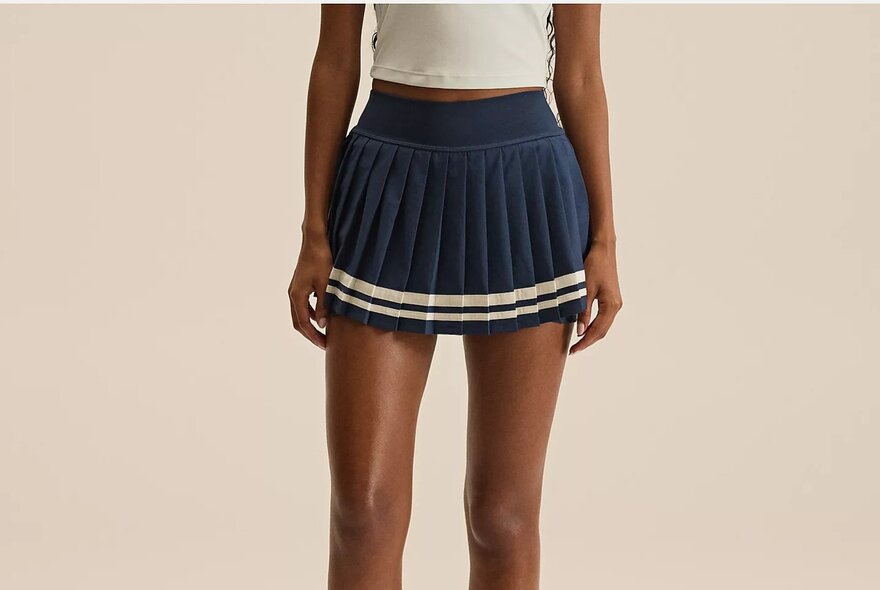 A woman is wearing a tennis skirt