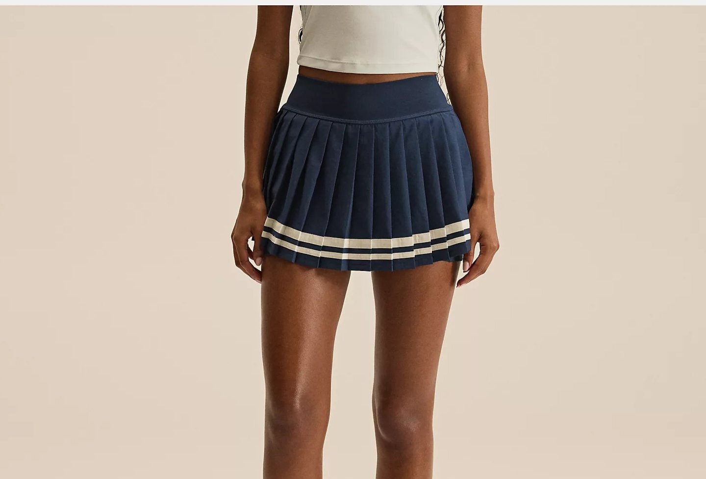 A woman is wearing a tennis skirt