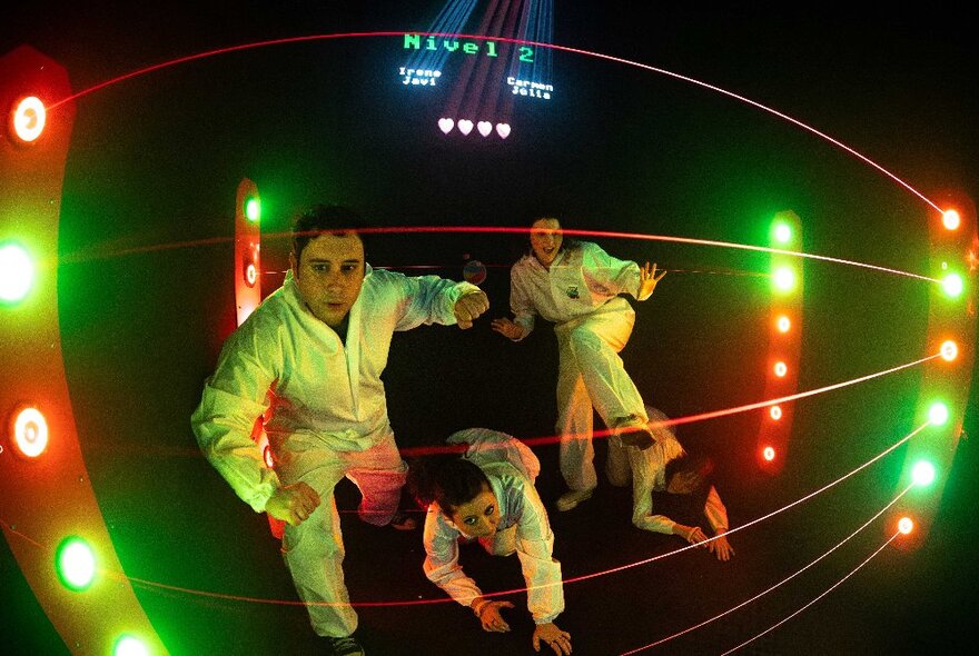 People wearing white suits in a dark room with bright lights.