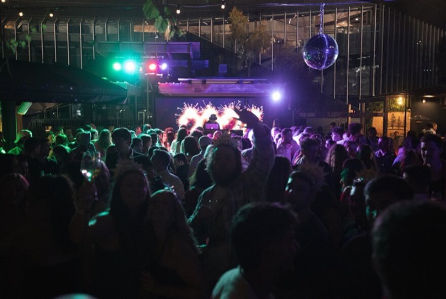 People dancing inside a dark nightclub.
