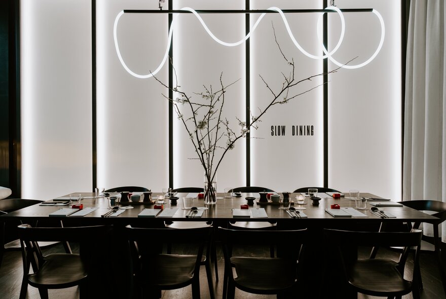 Neon and floral decor at a long table set for dining.