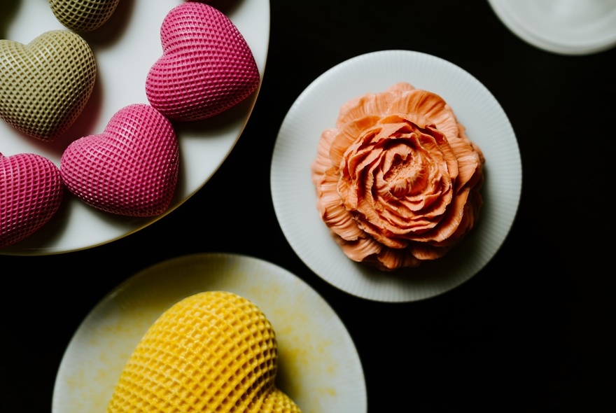 Dishes of heart- and flower-shaped desserts.